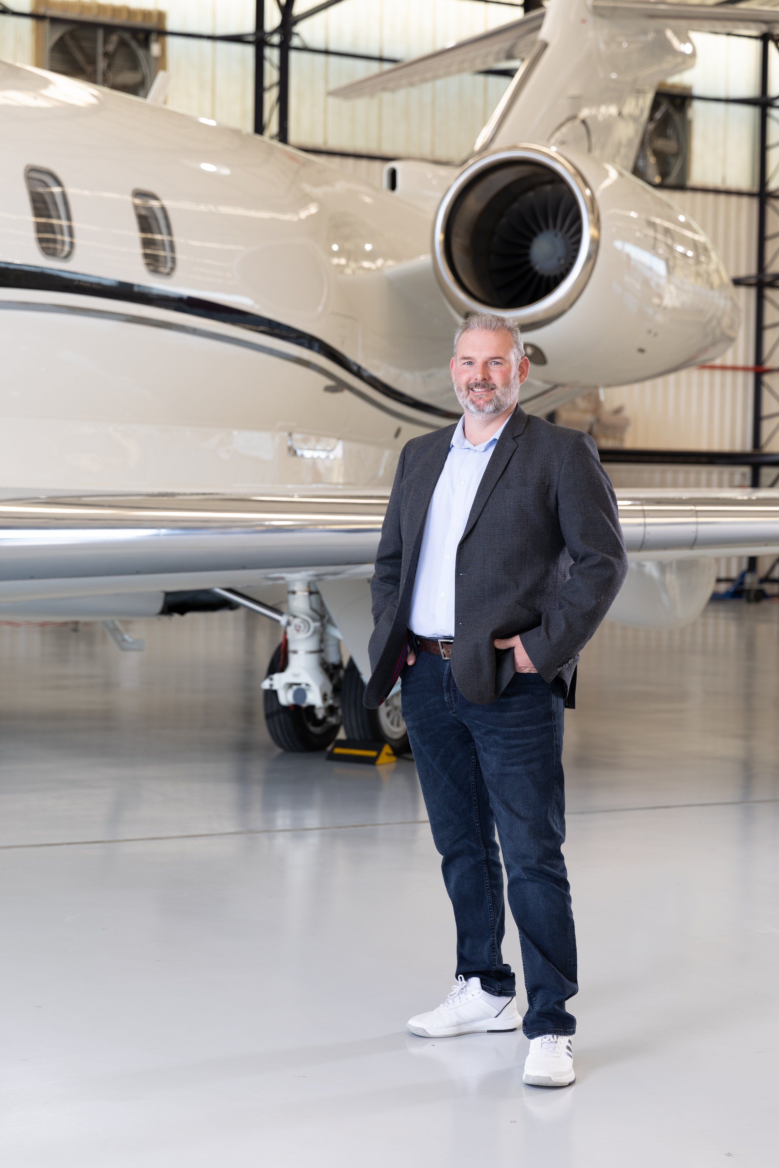 David Howarth standing in a hangar in front of a business jet
